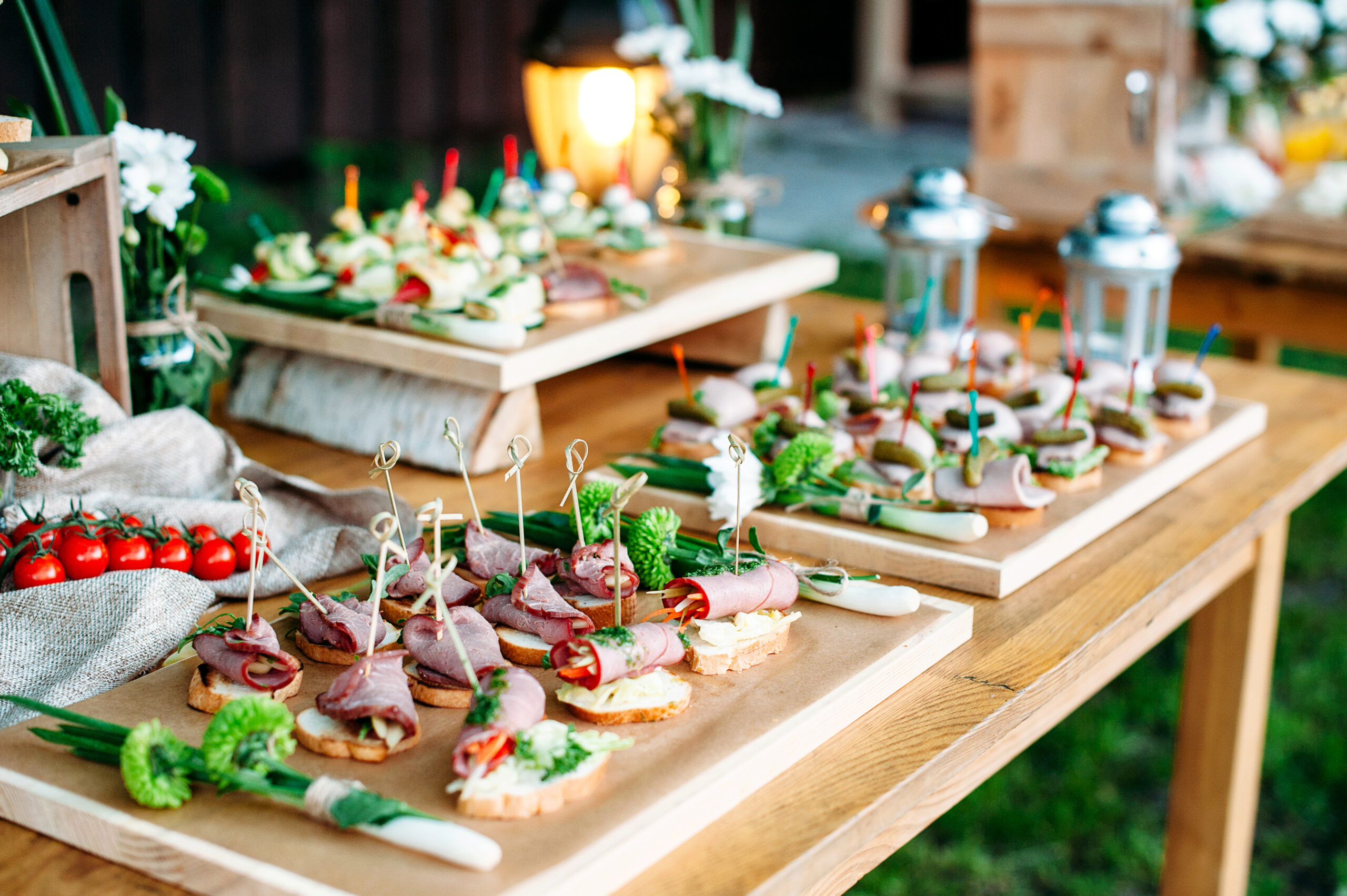Beautiful catering banquet table decorated in rustic style. Different snacks and sandwiches