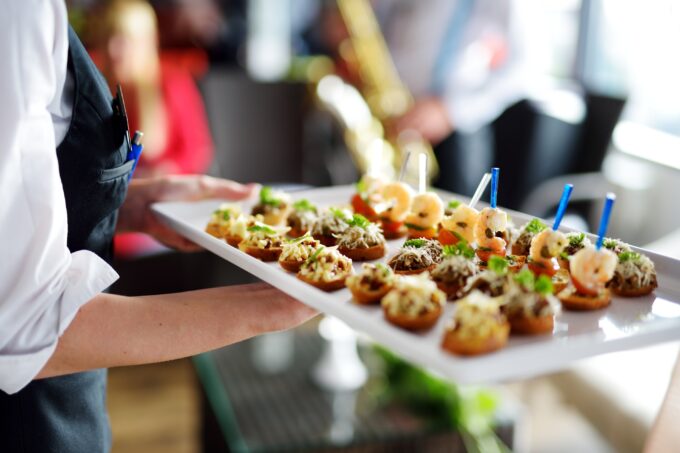 Caterer carrying plates at graduation party
